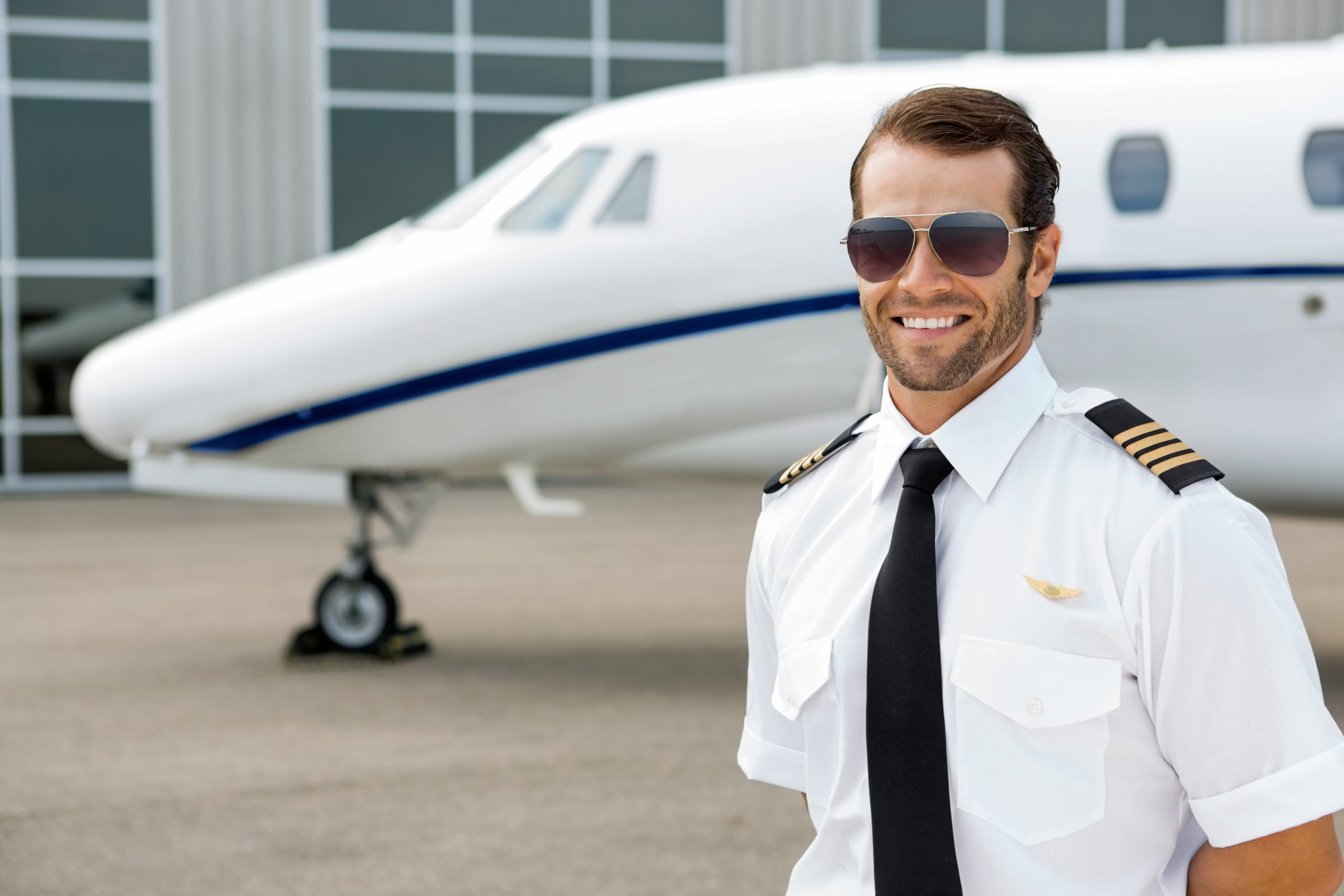 Confident,Pilot,Smiling,In,Front,Of,Private,Jet